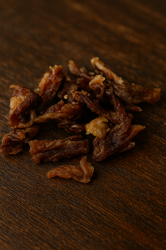 Dehydrated lamb jerky pieces on a wooden surface